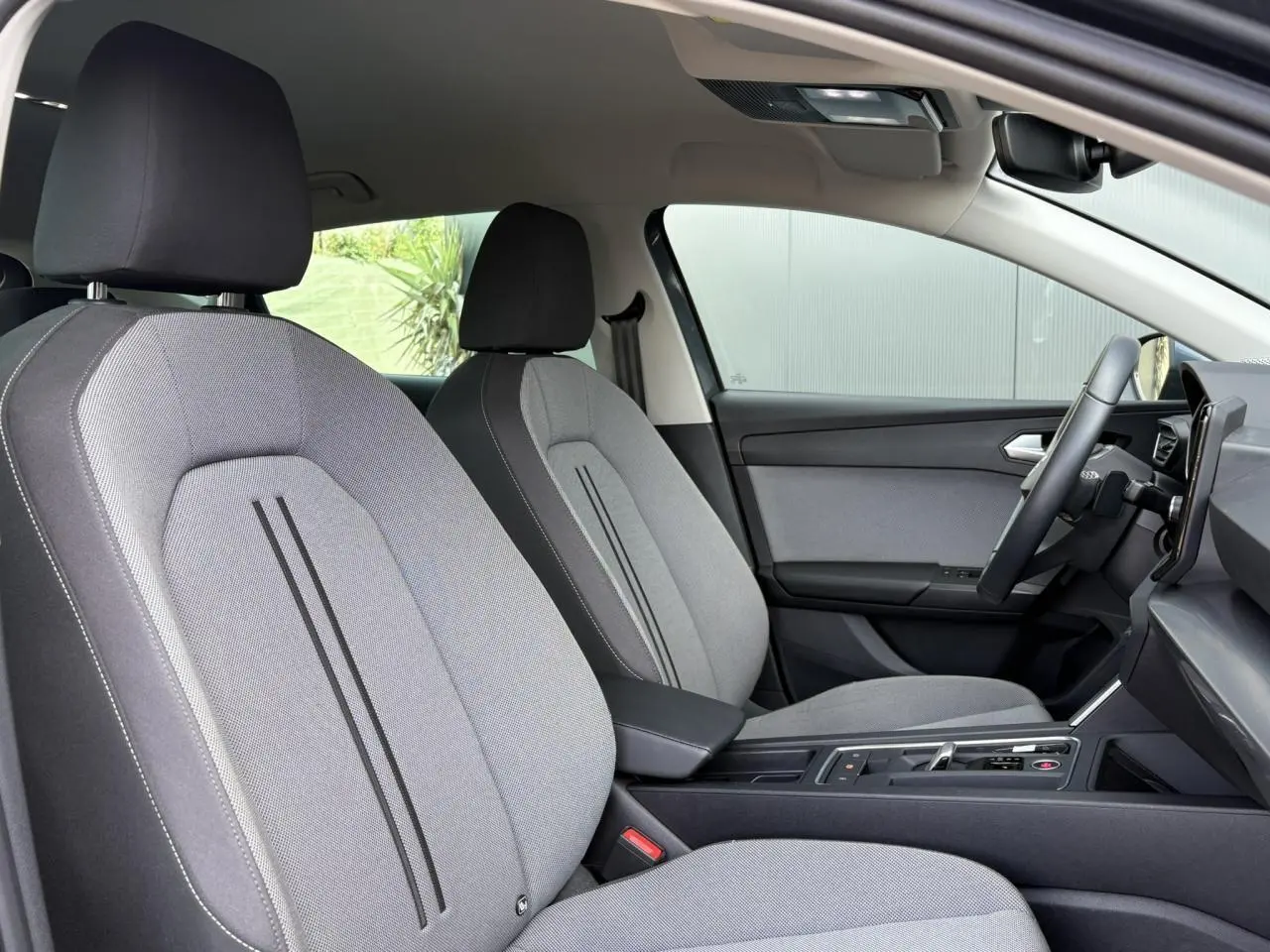 Vue intérieure côté conducteur du SEAT LEON 2.0 TDI 150 DSG Style 2024 avec sièges gris et volant cuir multifonction.