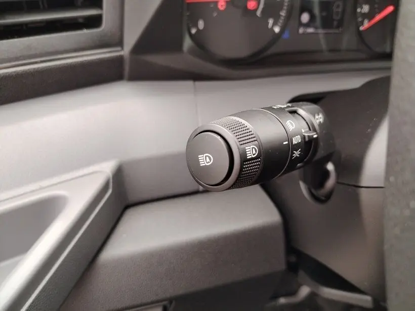 Gros plan sur la commande des phares du Nissan Interstar Fourgon 2026, intérieur gris et noir.