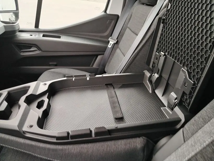 Vue intérieure côté droit du Nissan Interstar Fourgon 2026, montrant le siège passager gris et un plateau de rangement ouvert.