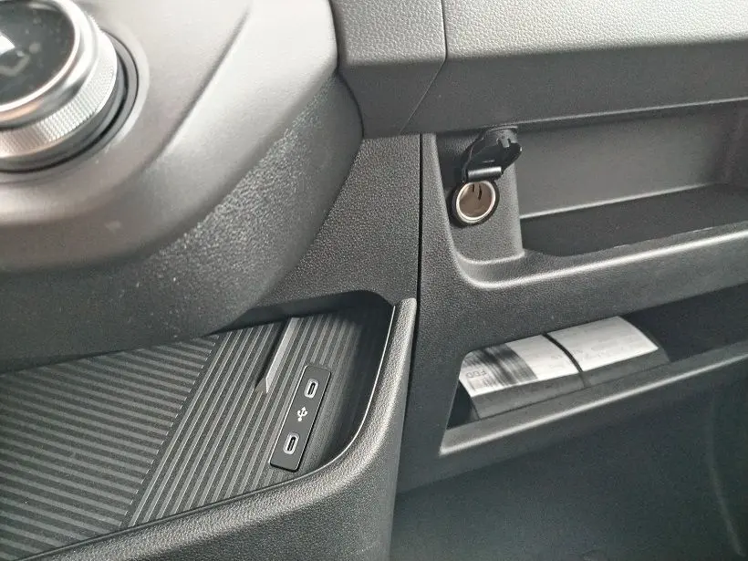 Détail intérieur du tableau de bord noir du Nissan Interstar Fourgon avec prise USB et allume-cigare visible.