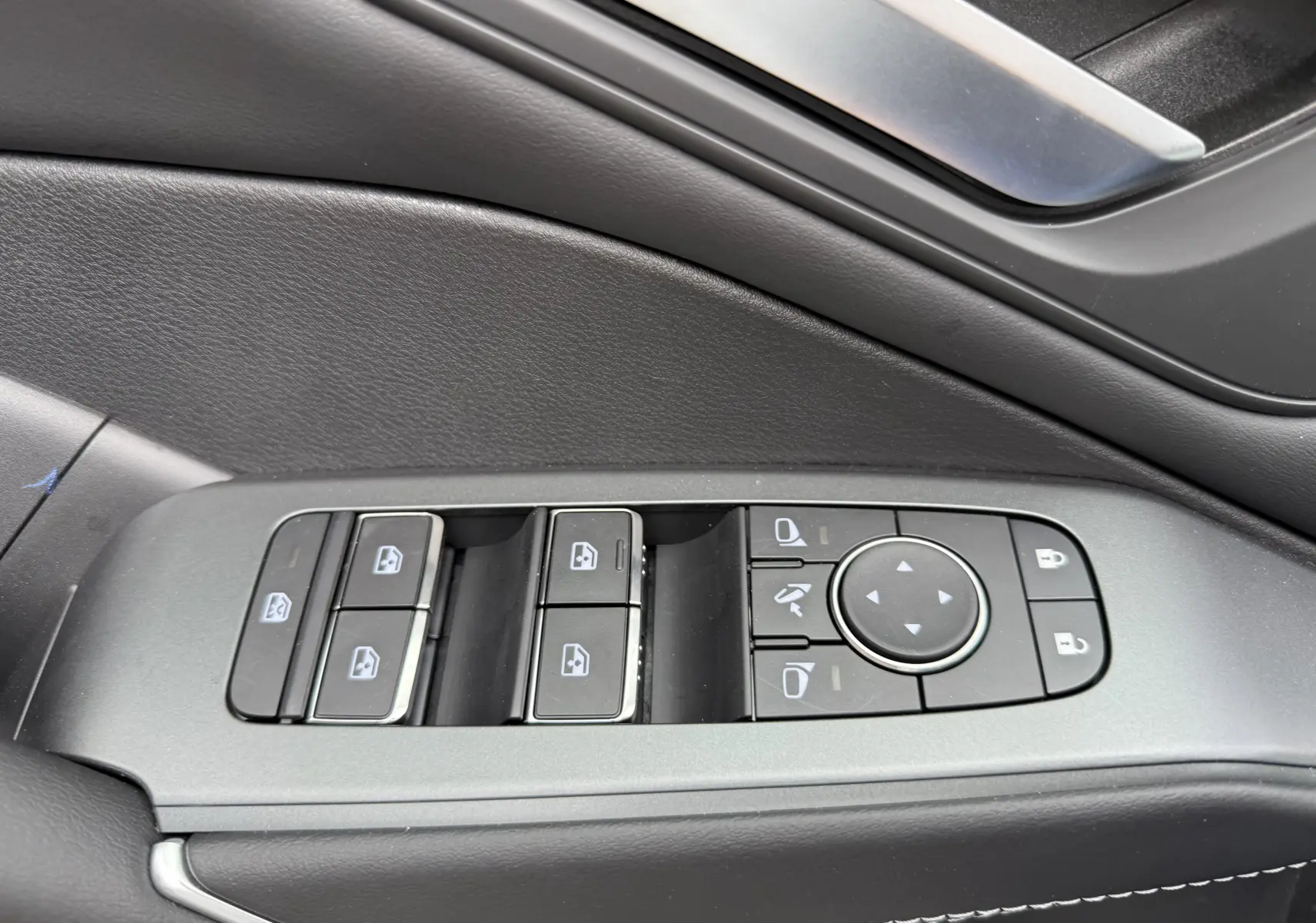 Panneau de commandes des vitres et rétroviseurs côté gauche intérieur noir du Nissan Qashqai blanc nacré 2025.