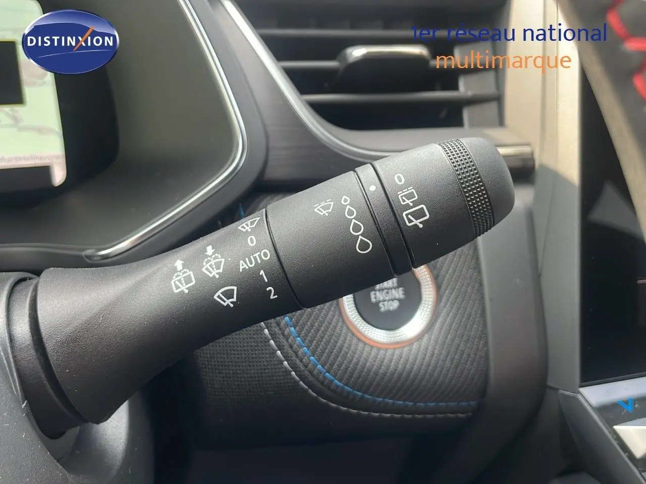 Gros plan sur la commande d’essuie-glace du Renault Captur E-Tech gris Cassiopée, avec bouton start/stop en arrière-plan.