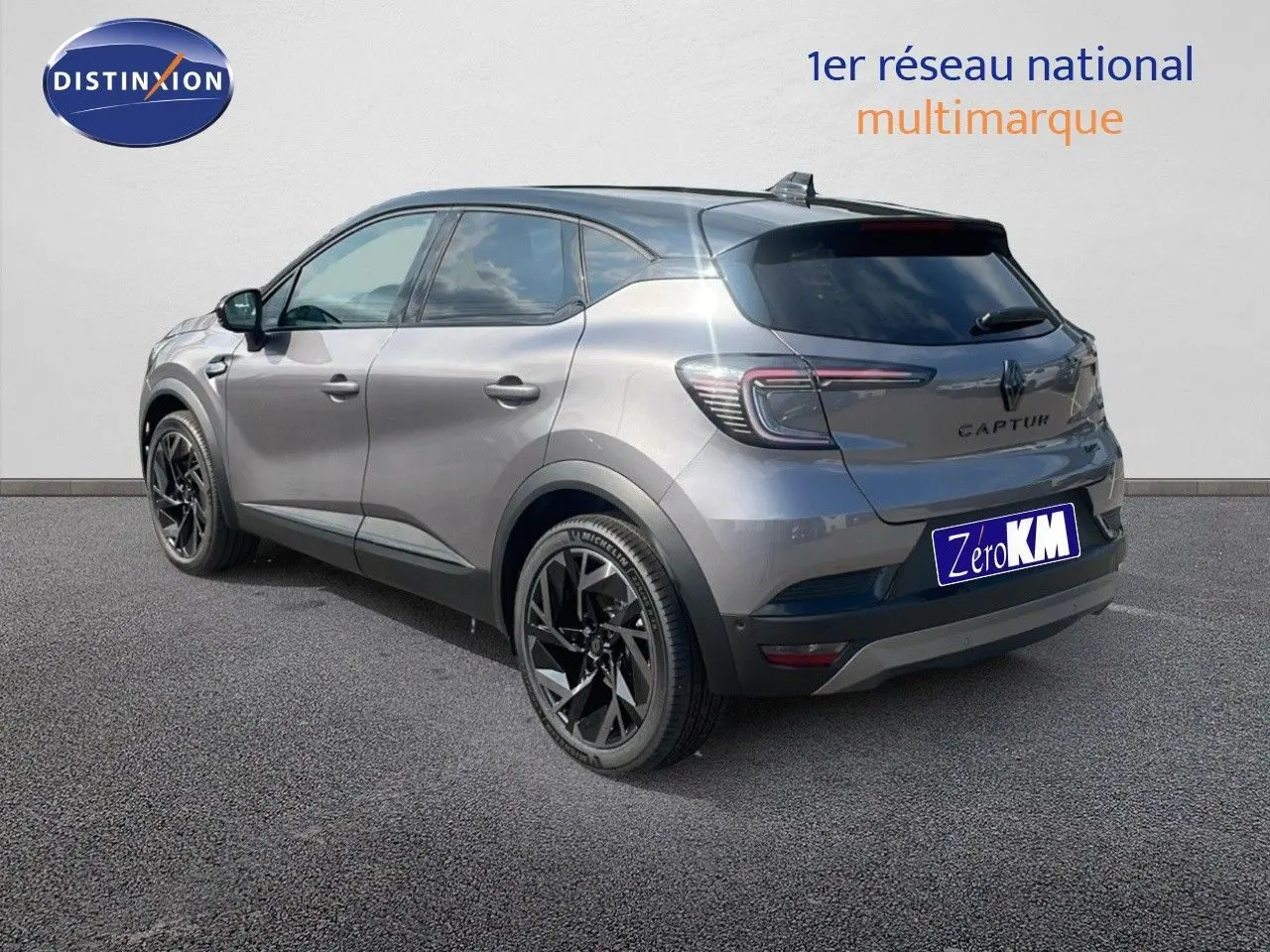 Vue 3/4 arrière droite du Renault Captur E-Tech hybride gris Cassiopée avec toit noir et jantes noires distinctives.