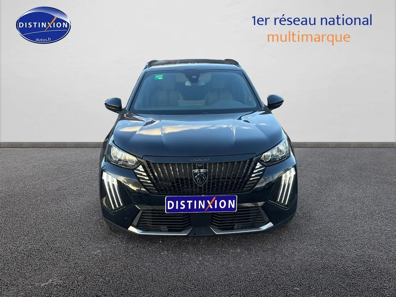 Vue frontale d'un Peugeot 2008 noir 2025 avec calandre verticale et feux LED en griffes distinctifs.