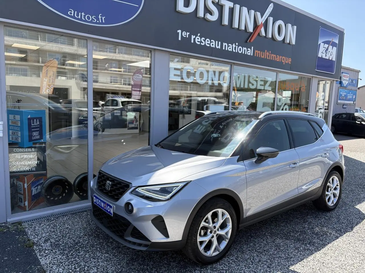 SEAT Arona 2024 gris GRS en 3/4 avant droit, jantes alliage 16 pouces et calandre noire distinctive.