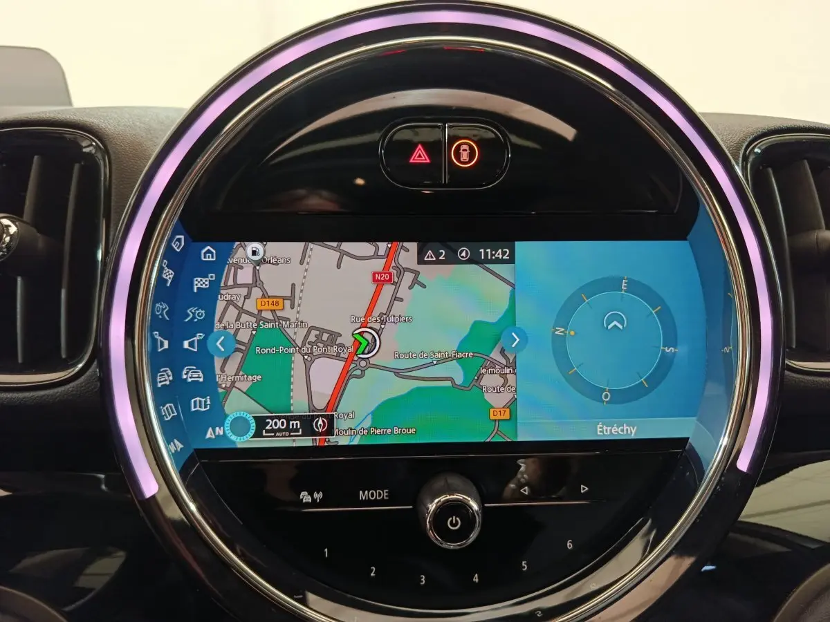 Écran tactile central rond du tableau de bord du MINI Countryman blanc, affichant la navigation GPS en mode jour.