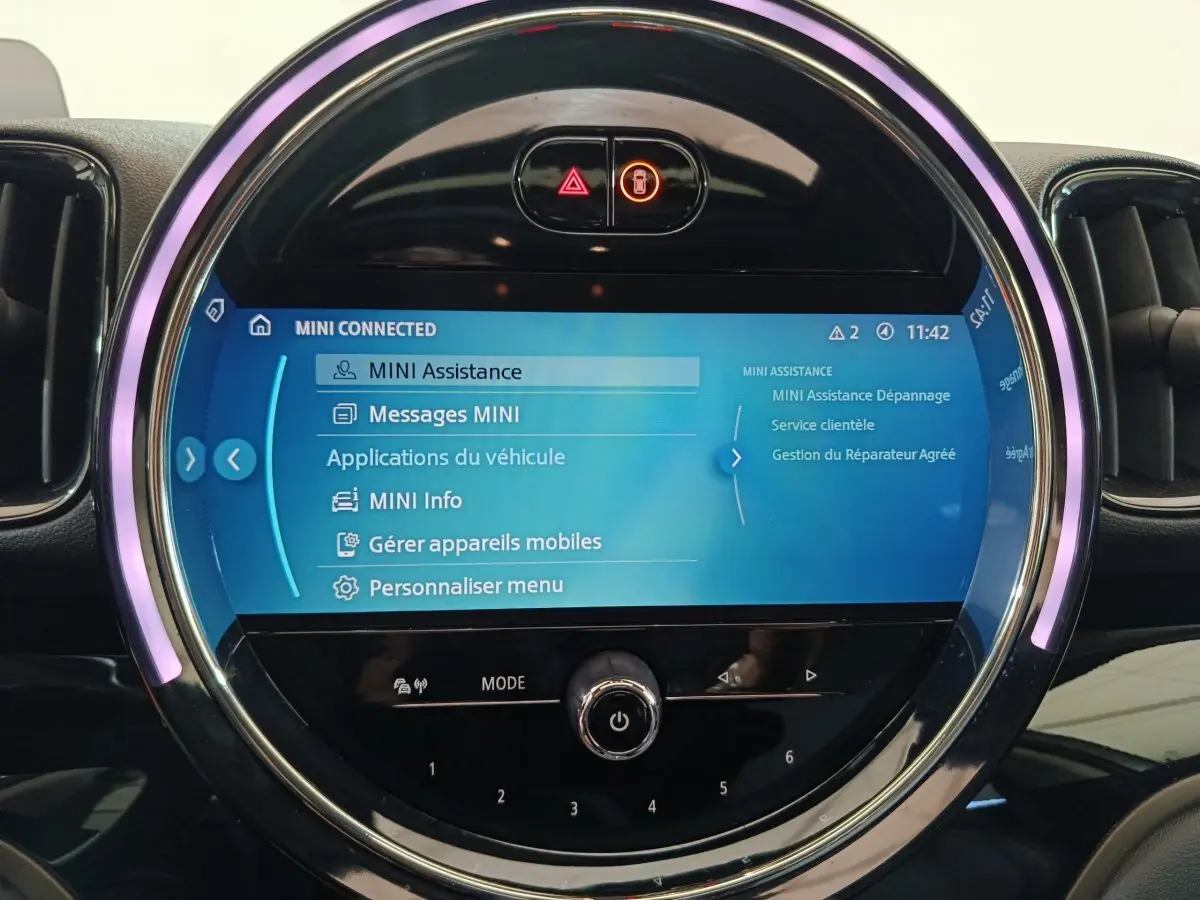 Écran tactile central circulaire allumé du MINI Countryman blanc, affichant le menu MINI Connected.