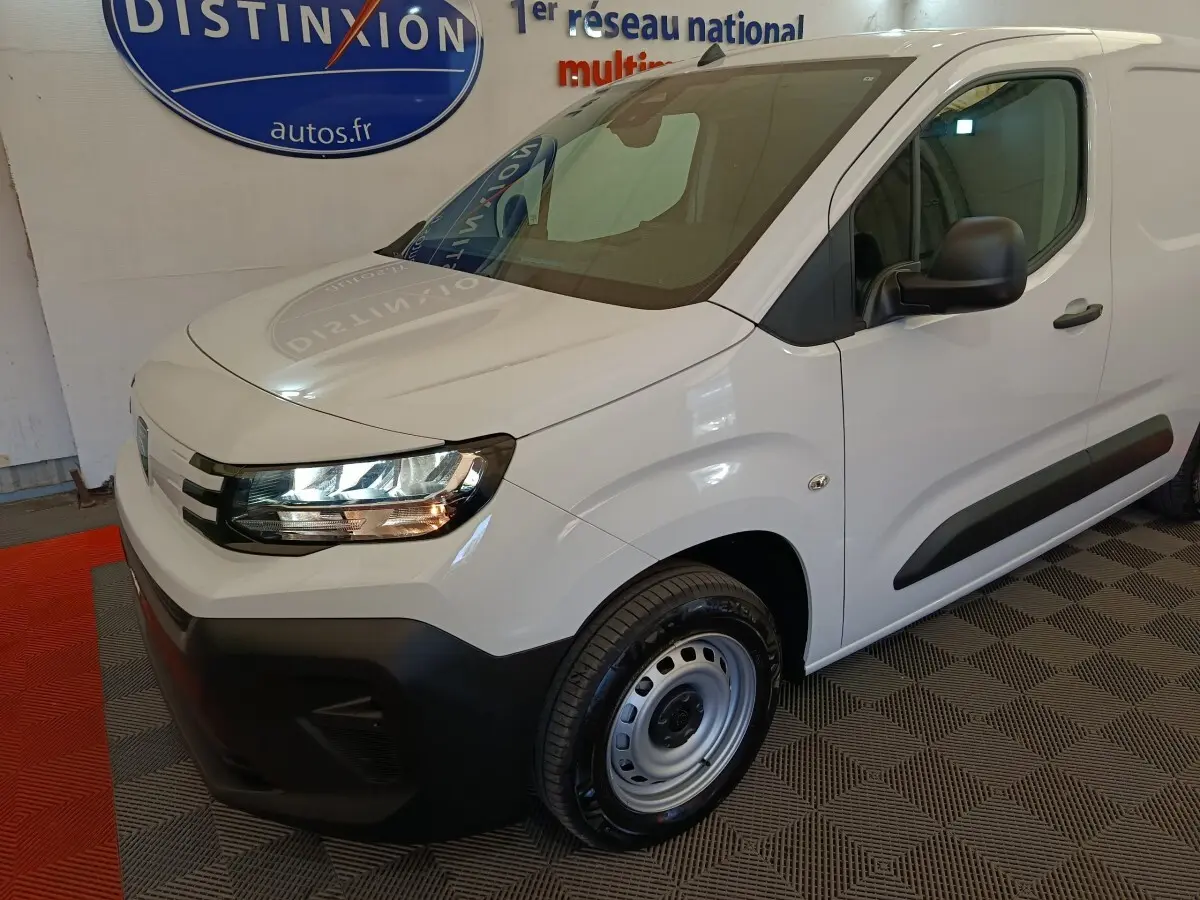 Vue 3/4 avant droit d'un utilitaire Peugeot Partner blanc avec pare-chocs noirs et jantes acier simples.