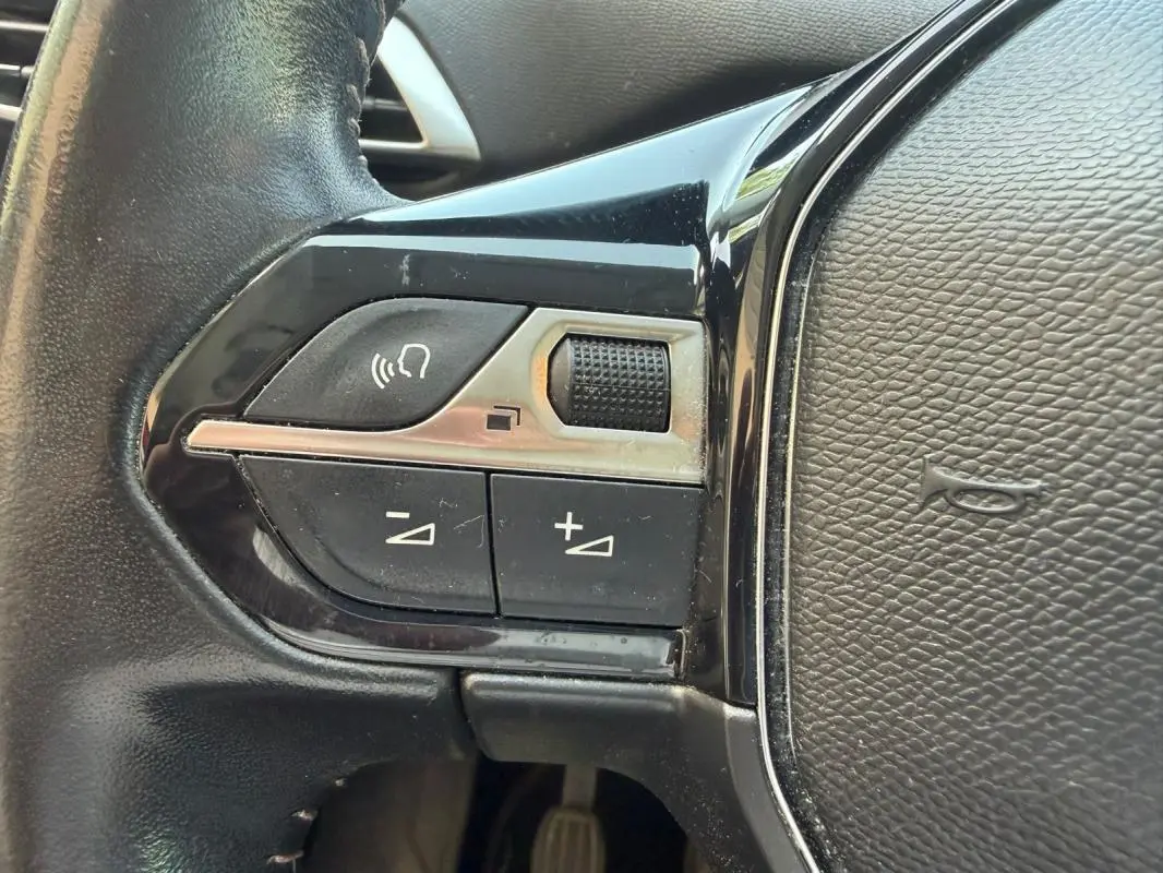 Détail des commandes au volant noir du Peugeot 3008 2021, boutons de volume et de téléphone visibles.