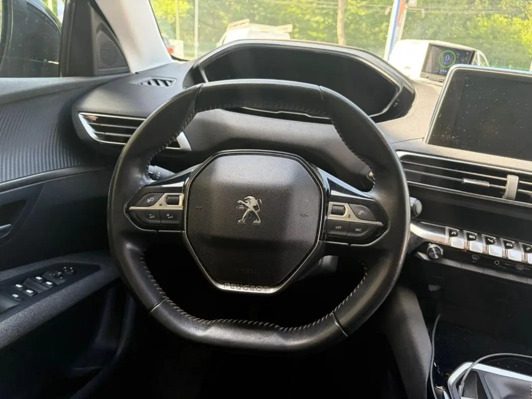 Vue intérieure centrée sur le volant noir du Peugeot 3008 2021 avec tableau de bord et commandes visibles.