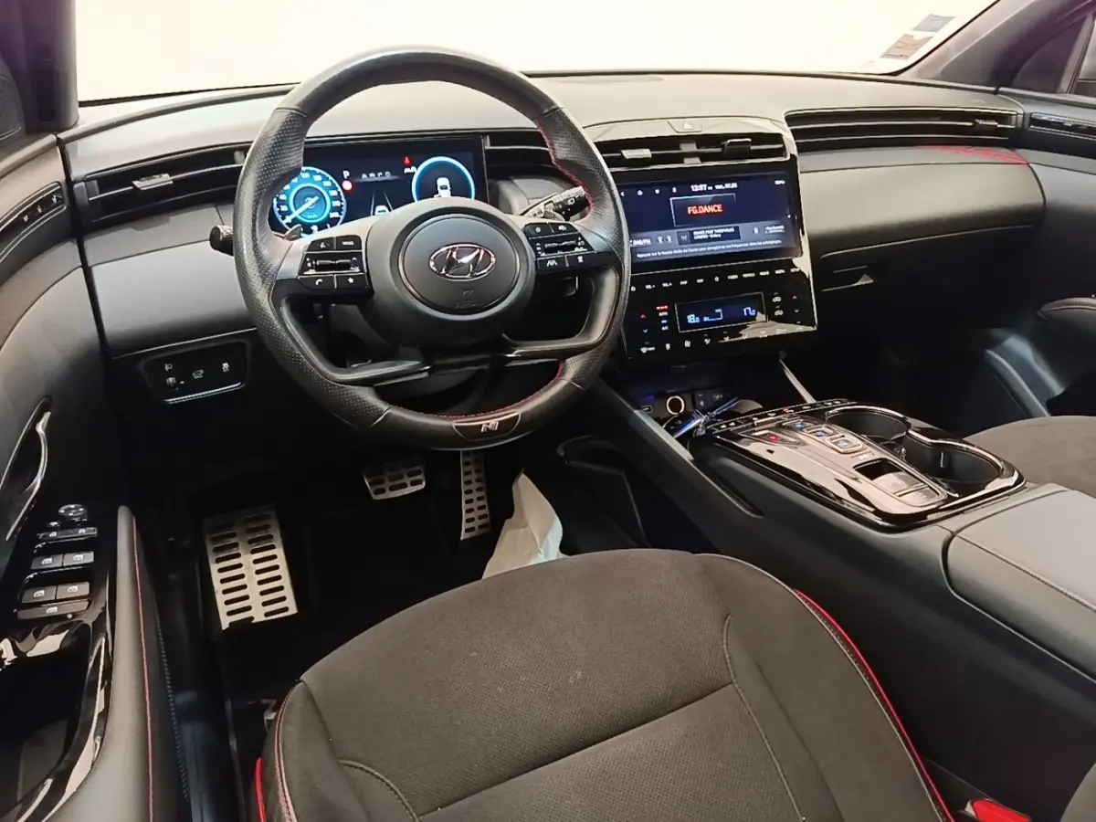 Intérieur noir du Hyundai Tucson 2022, vue avant centrée sur le volant multifonctions et l’écran tactile central.