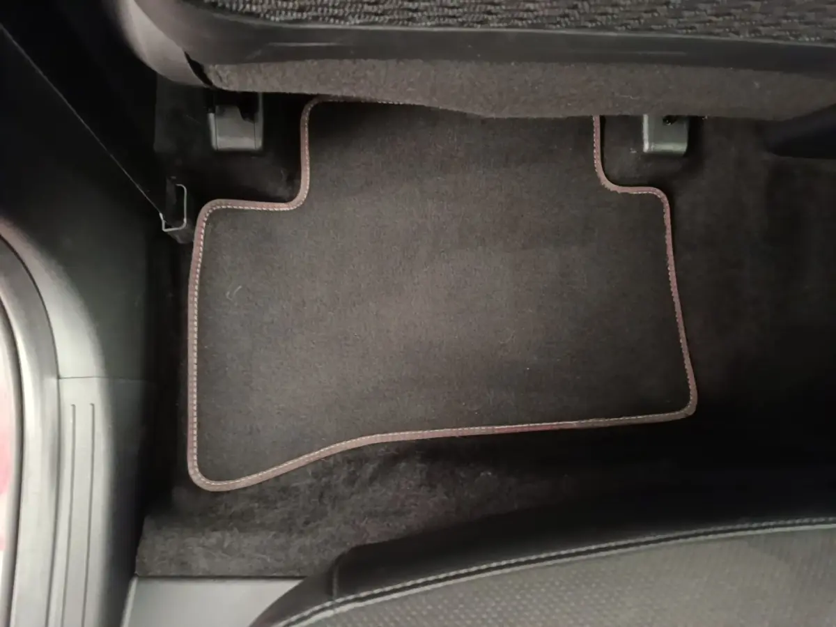 Tapis de sol noir avec surpiqûres rouges côté conducteur dans un Hyundai Tucson 2022 hybride diesel.