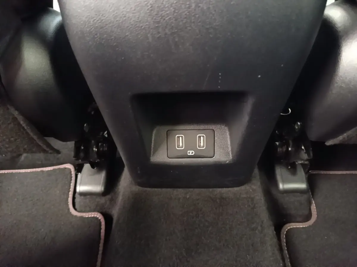 Prise USB double vue en gros plan sous la console centrale arrière d’un Hyundai Tucson rouge.