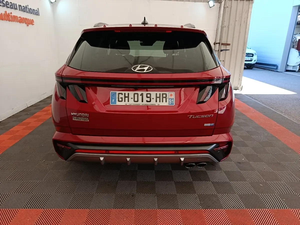 Vue arrière d’un Hyundai Tucson rouge 2022 avec feux LED et double sortie d’échappement chromée.