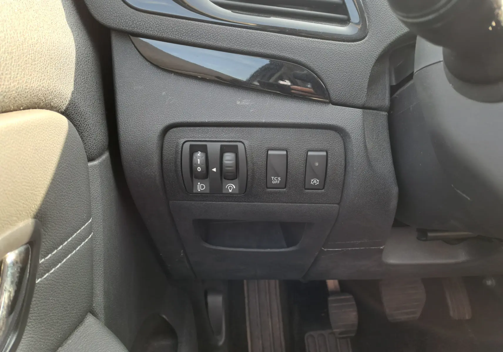 Gros plan sur les commandes à gauche du volant dans l'habitacle gris foncé du Renault Scénic III 2016.