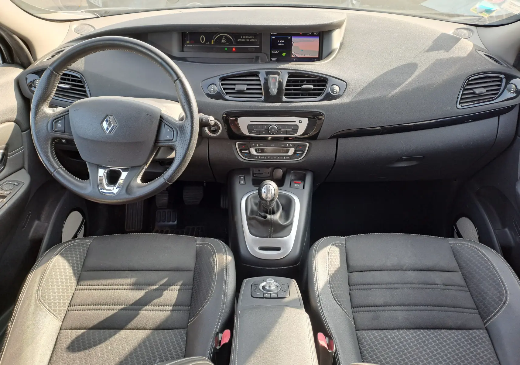 Intérieur noir du Renault Scénic III 1.2 TCE 130 Intens 2016, tableau de bord avec écran et boîte manuelle visible.