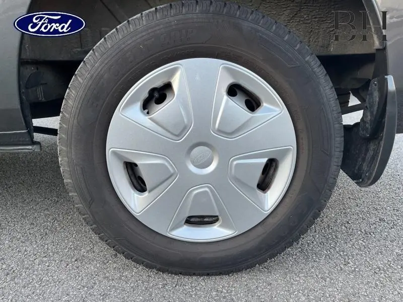 Gros plan sur la roue avant droite du Ford Transit Custom gris métallisé avec enjoliveur argenté et pneu noir.