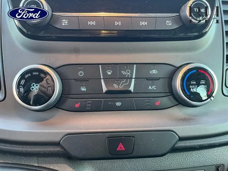 Vue rapprochée du tableau de bord du Ford Transit Custom gris, montrant les commandes de climatisation et chauffage.