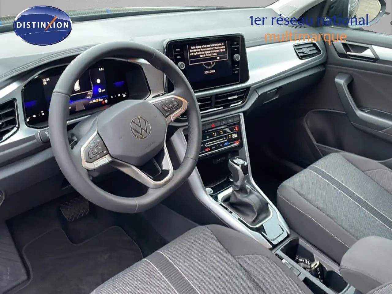 Vue intérieure côté conducteur du Volkswagen T-Roc noir Grenadilla, avec tableau de bord digital et console centrale moderne.