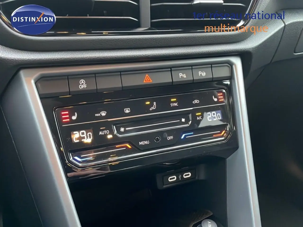 Vue intérieure centrée sur la console centrale du Volkswagen T-Roc noir, affichant la climatisation digitale à 29°C.