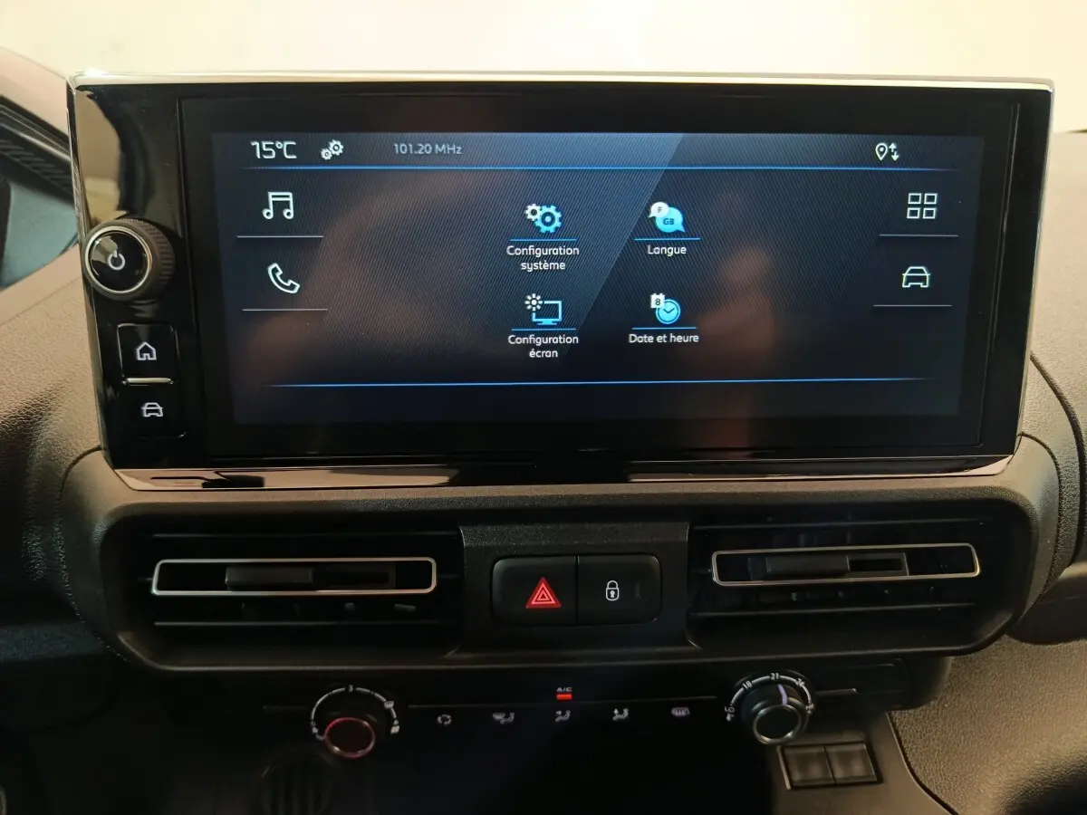 Écran tactile central du tableau de bord du Peugeot Partner blanc, avec commandes de climatisation et alertes visibles.