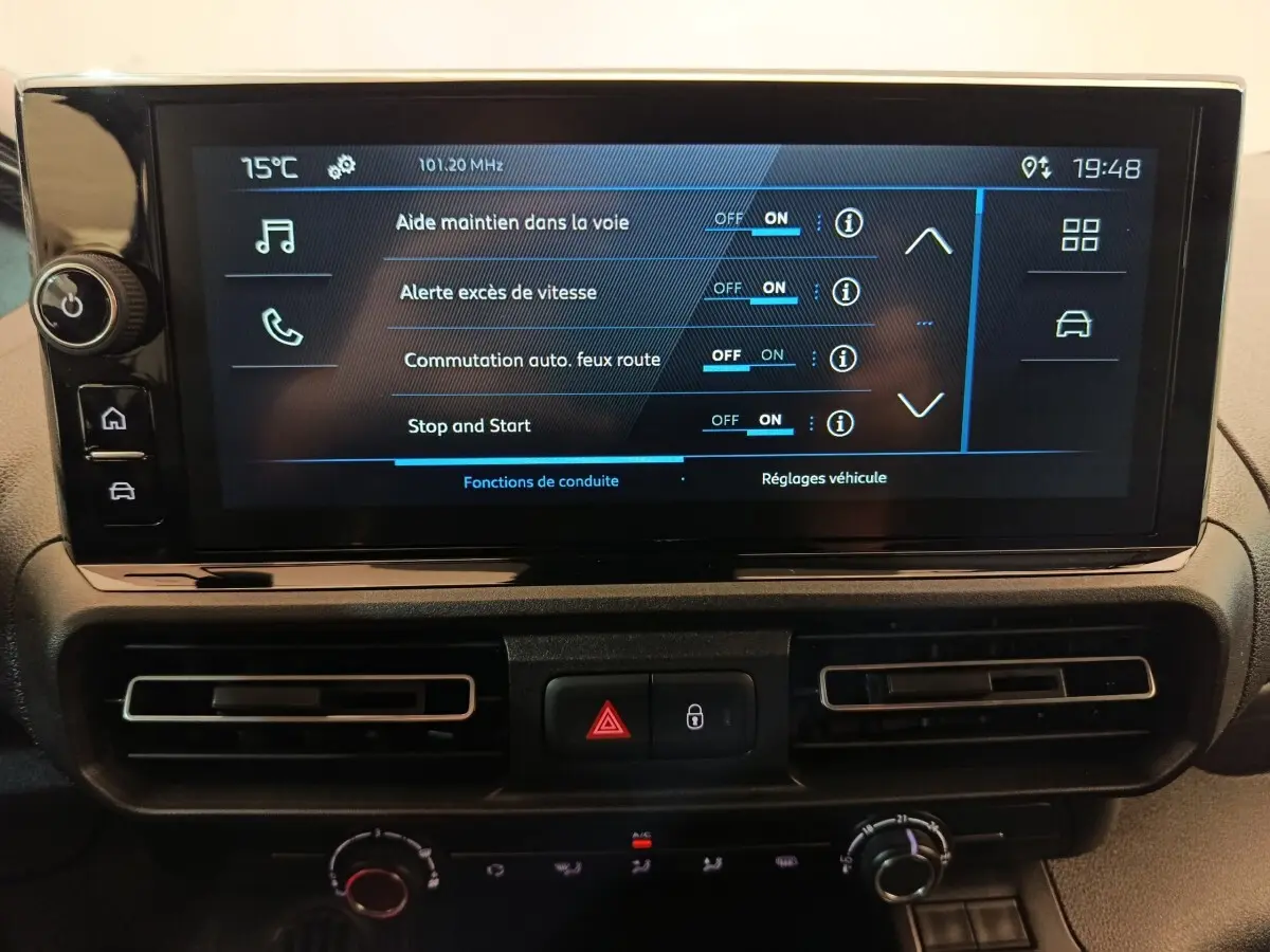 Écran tactile central du Peugeot Partner 2025 montrant les réglages d’aides à la conduite, avec commandes climatisation en dessous.