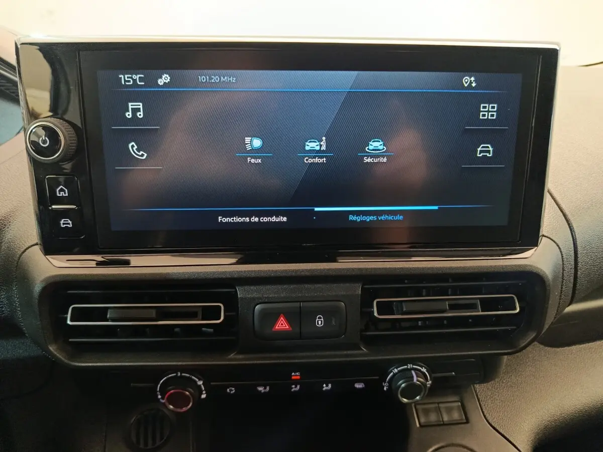 Vue rapprochée de l’écran tactile central et des commandes de climatisation du Peugeot Partner blanc 2025.