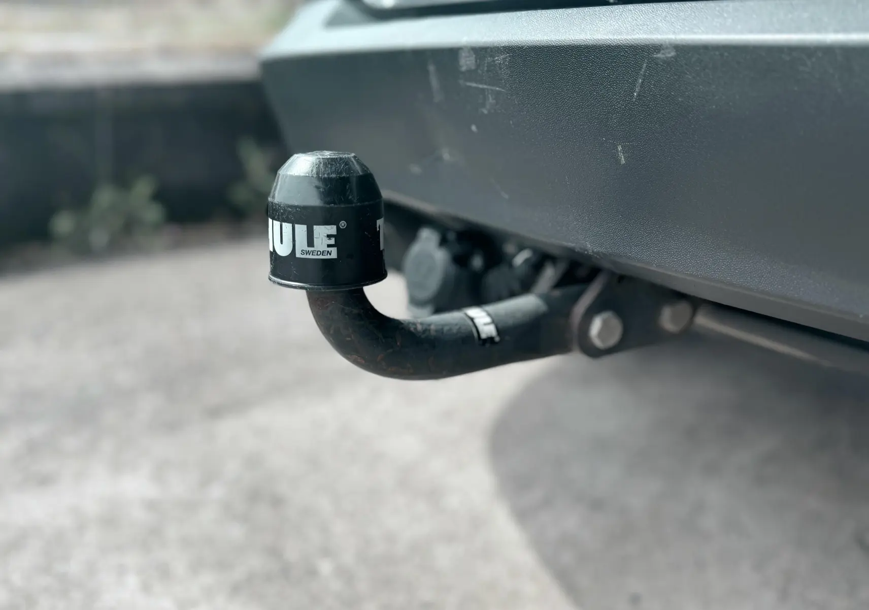Gros plan sur l'attelage d'une Volkswagen Tiguan noire de 2007, visible sous le pare-chocs arrière.
