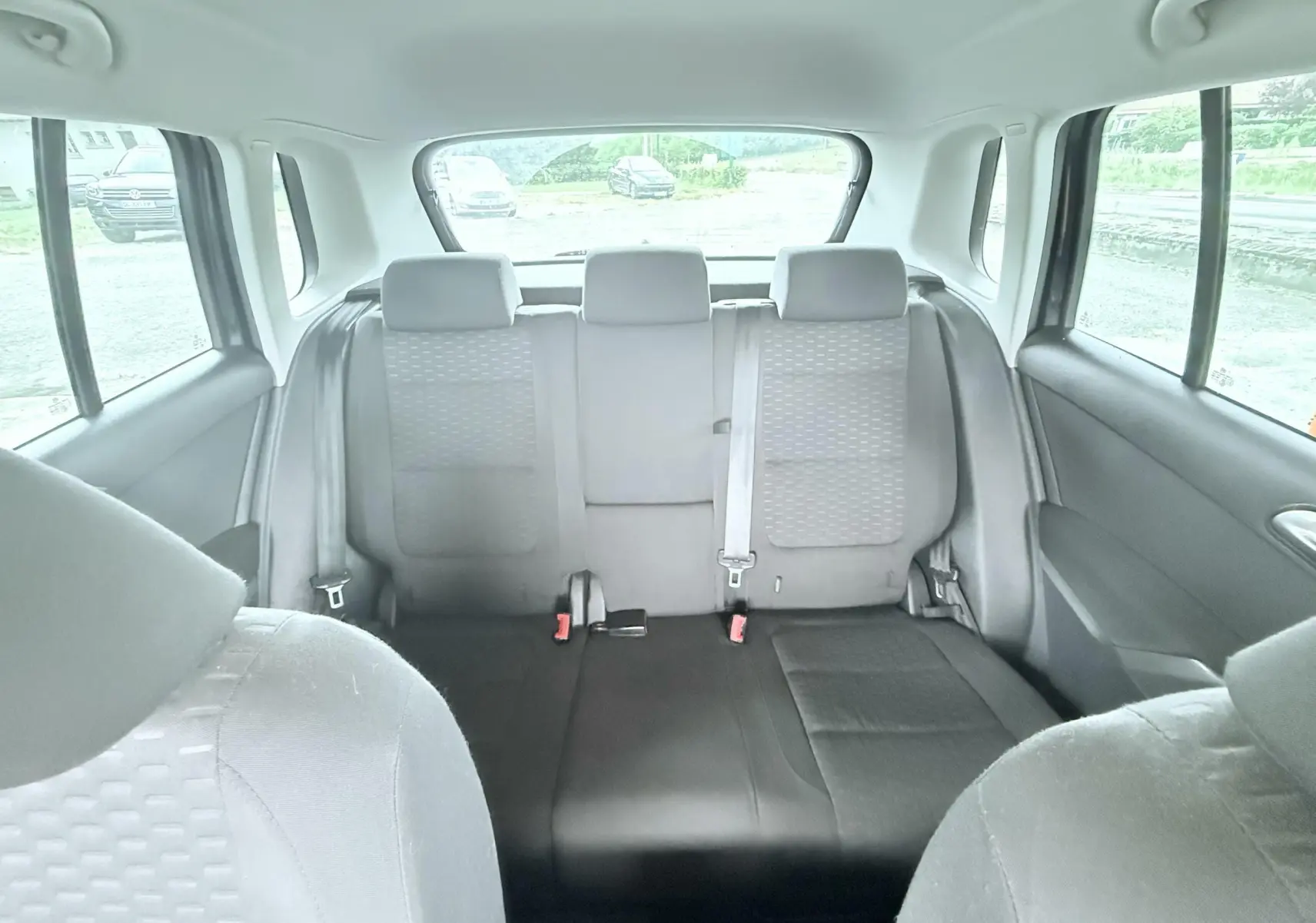 Vue intérieure arrière du Volkswagen Tiguan 2007, sièges tissu noir et ceinture de sécurité centrale visible.