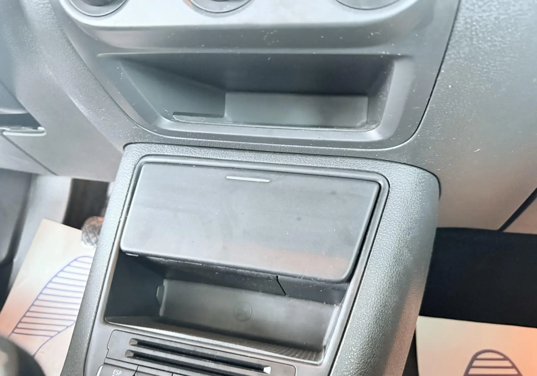 Vue rapprochée de la console centrale noire du Volkswagen Tiguan 2007, avec rangement et commandes visibles.