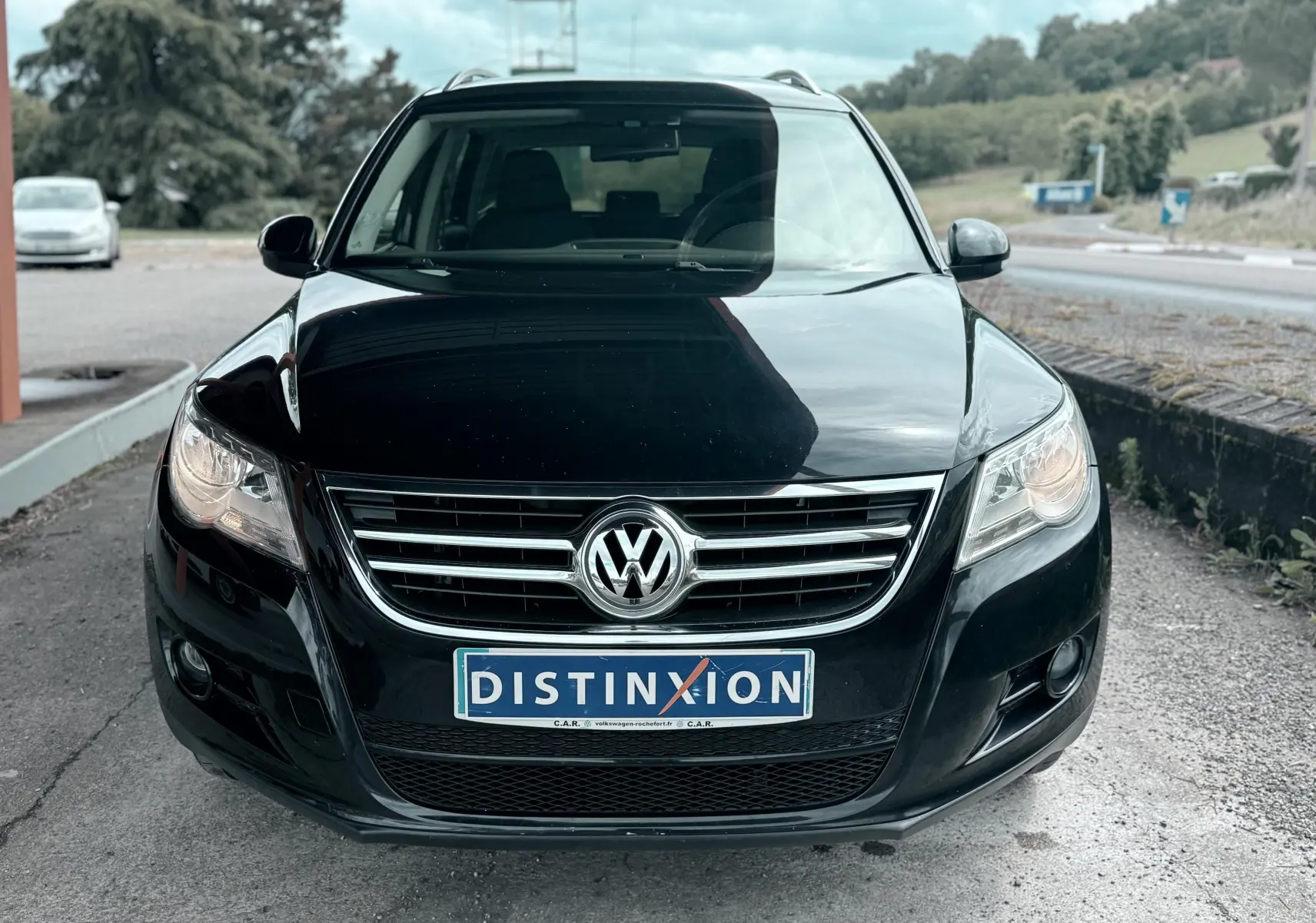 Vue avant d’un Volkswagen Tiguan noir 2007 avec calandre chromée et plaque d’immatriculation Distinxion.