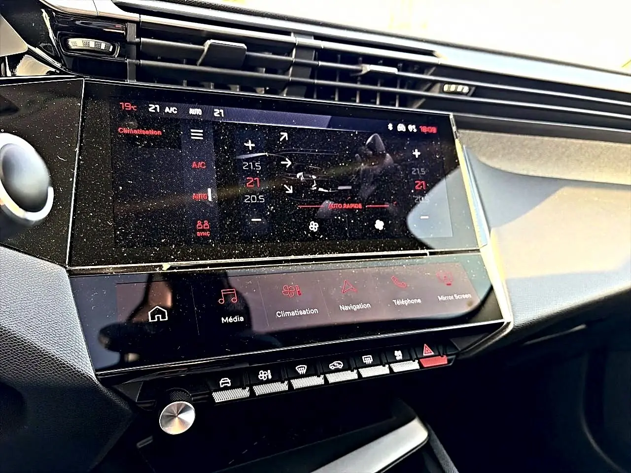 Vue rapprochée de la console centrale tactile du Peugeot 408 Hybrid 145 allure noir, affichant la climatisation et les commandes multimédia.