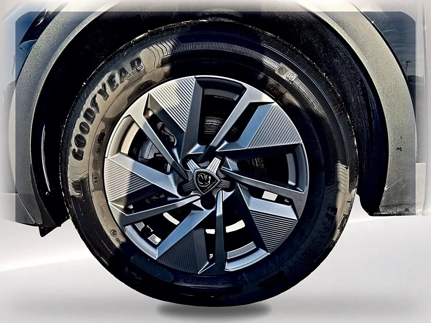 Gros plan sur la roue avant droite du Peugeot 408 noir, mettant en valeur la jante alu au design moderne.