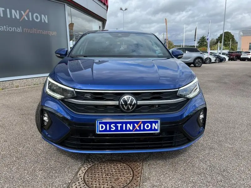 Vue frontale d'un Volkswagen Taigo 1.5 TSI R-Line bleu récif métallisé avec calandre noire et logo VW centré.