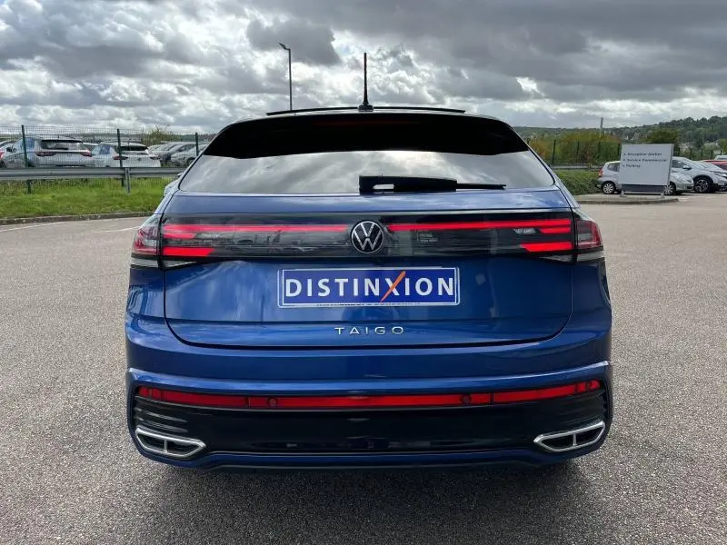 Vue arrière d'un Volkswagen Taigo bleu récif métallisé avec feux LED horizontaux et double sortie d'échappement intégrée.