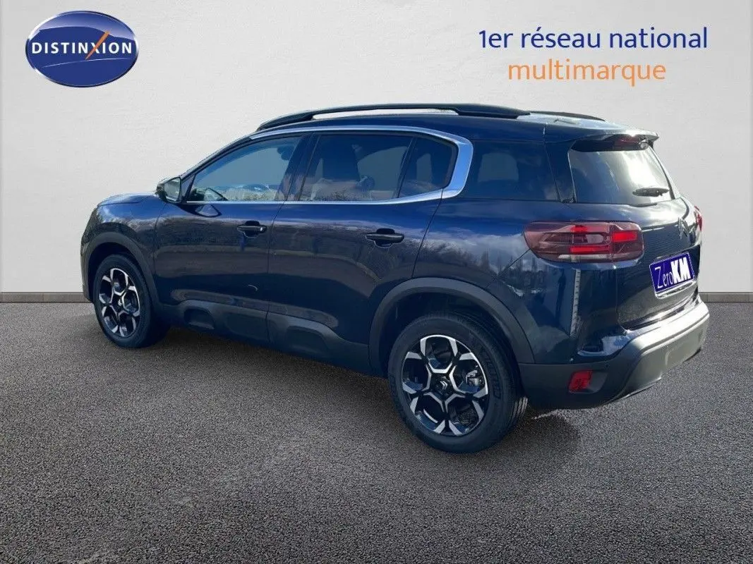 Vue latérale gauche d'un Citroën C5 Aircross 2025 bleu Eclipse Metal avec jantes bi-ton et toit noir.