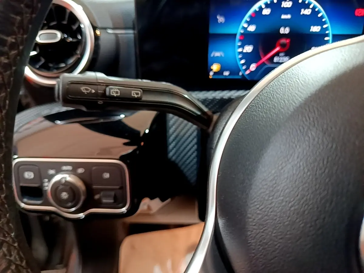 Gros plan sur le volant cuir et le combiné d'instruments numérique bleu de la Mercedes Classe A 180 d 2021.