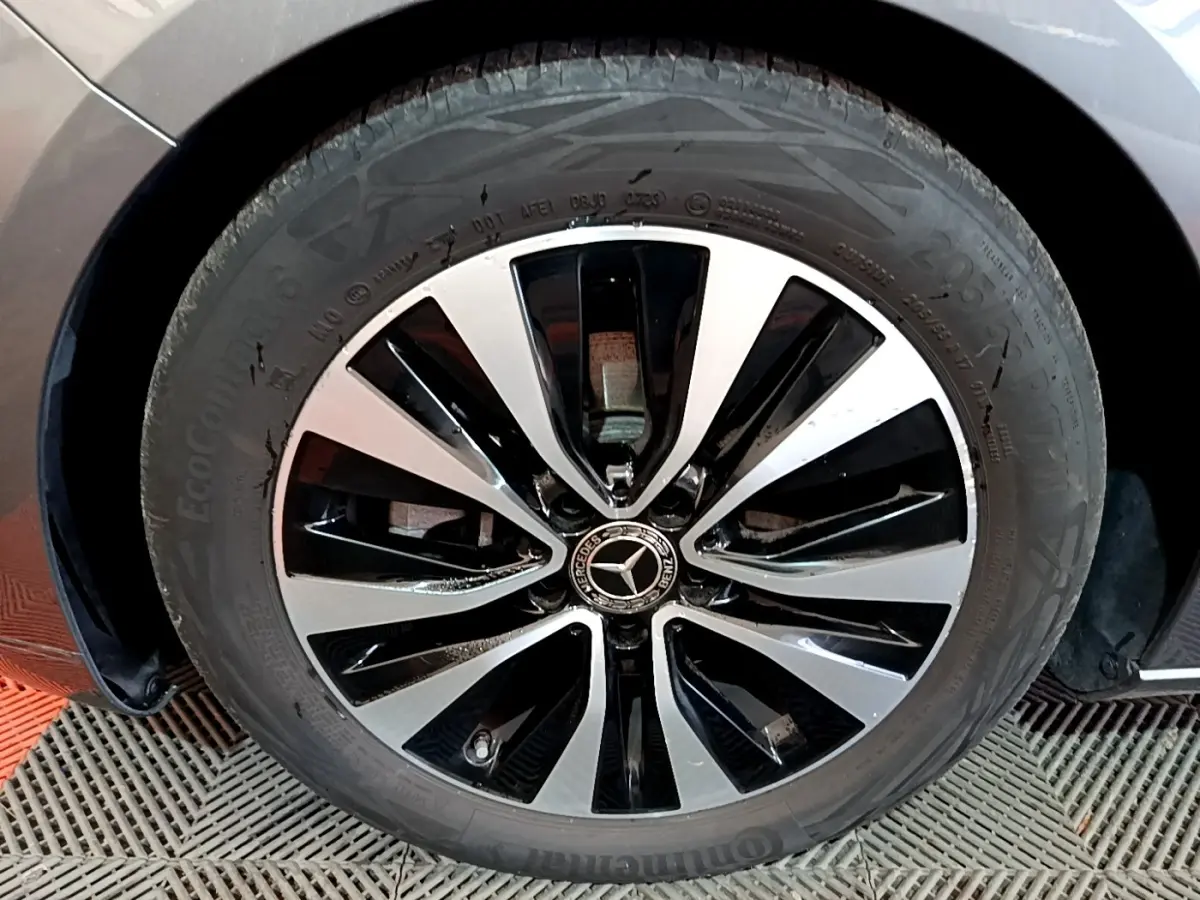 Gros plan sur la jante alliage bicolore noire et argentée du côté avant droit d'une Mercedes Classe A gris foncé.