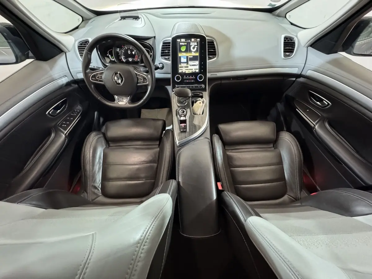 Vue intérieure avant du Renault Espace 2015 gris foncé, avec tableau de bord moderne et écran tactile vertical central.