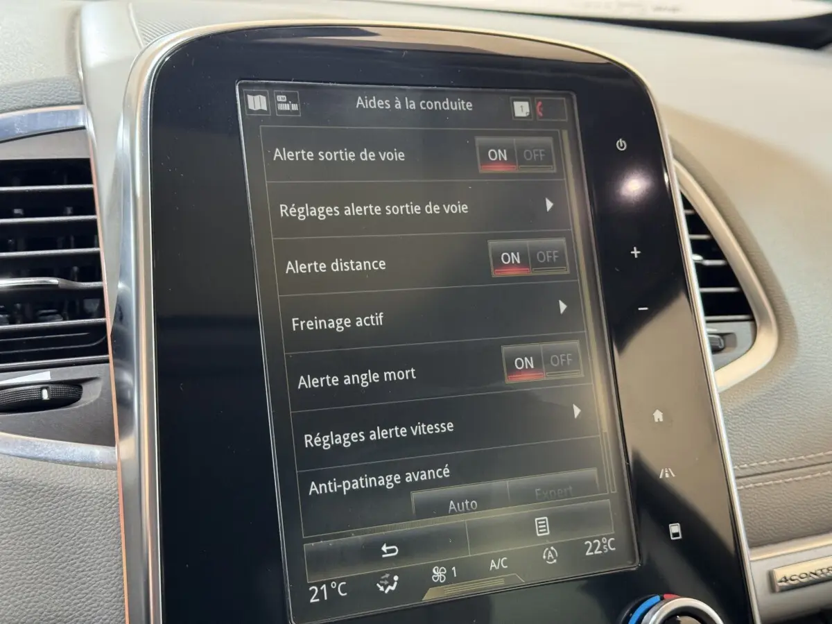Écran tactile central du tableau de bord du Renault Espace gris foncé, affichant les aides à la conduite activées.