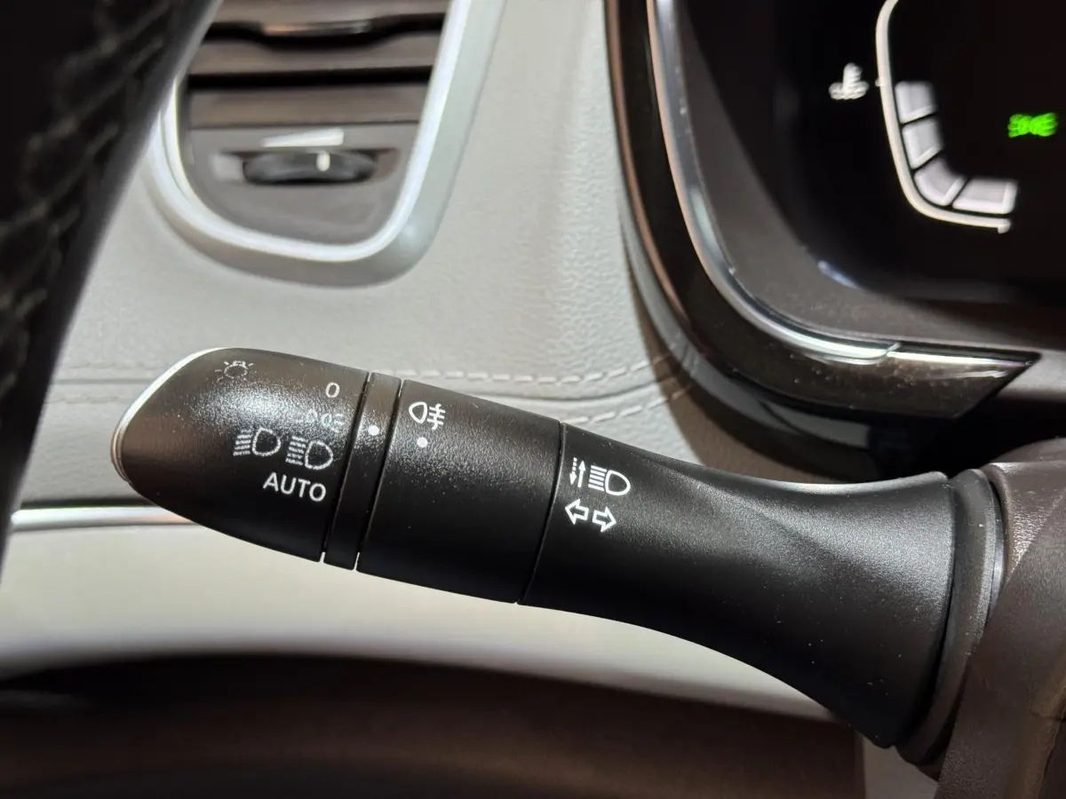 Gros plan sur la commande des phares et clignotants dans l’habitacle gris clair d’un Renault Espace 2015 Initiale Paris.