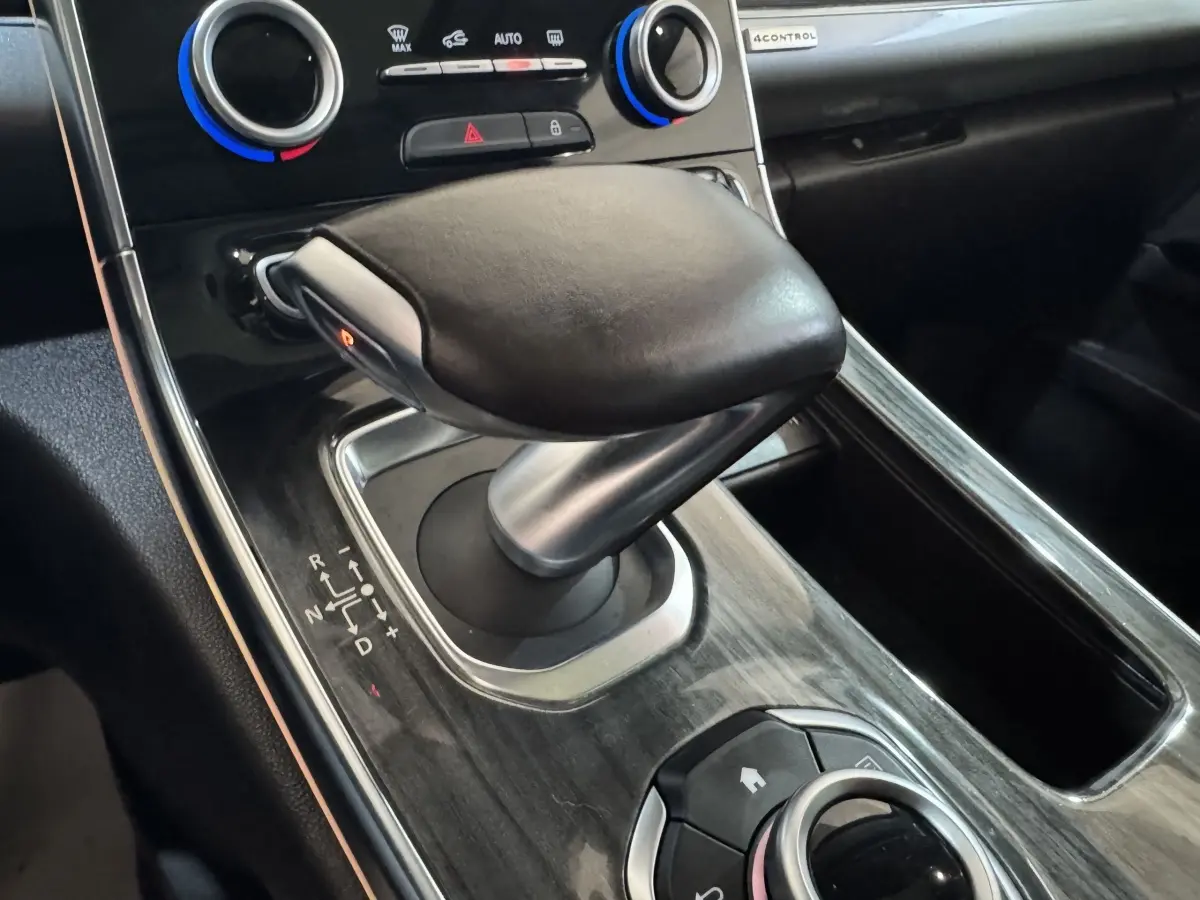 Gros plan sur la commande de boîte automatique en cuir noir et console en finition bois sombre du Renault Espace 2015.