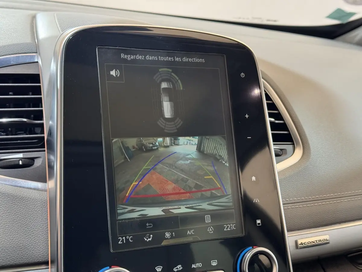Écran tactile central montrant la caméra de recul et l’aide au stationnement du Renault Espace gris foncé, vue intérieure avant.