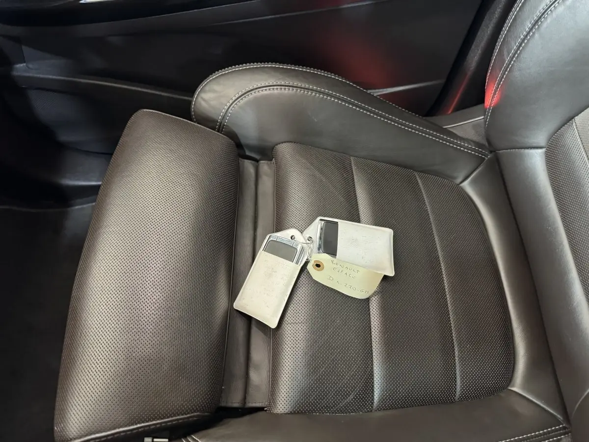 Gros plan sur le siège avant droit en cuir perforé gris foncé du Renault Espace 2015 avec clés posées dessus.