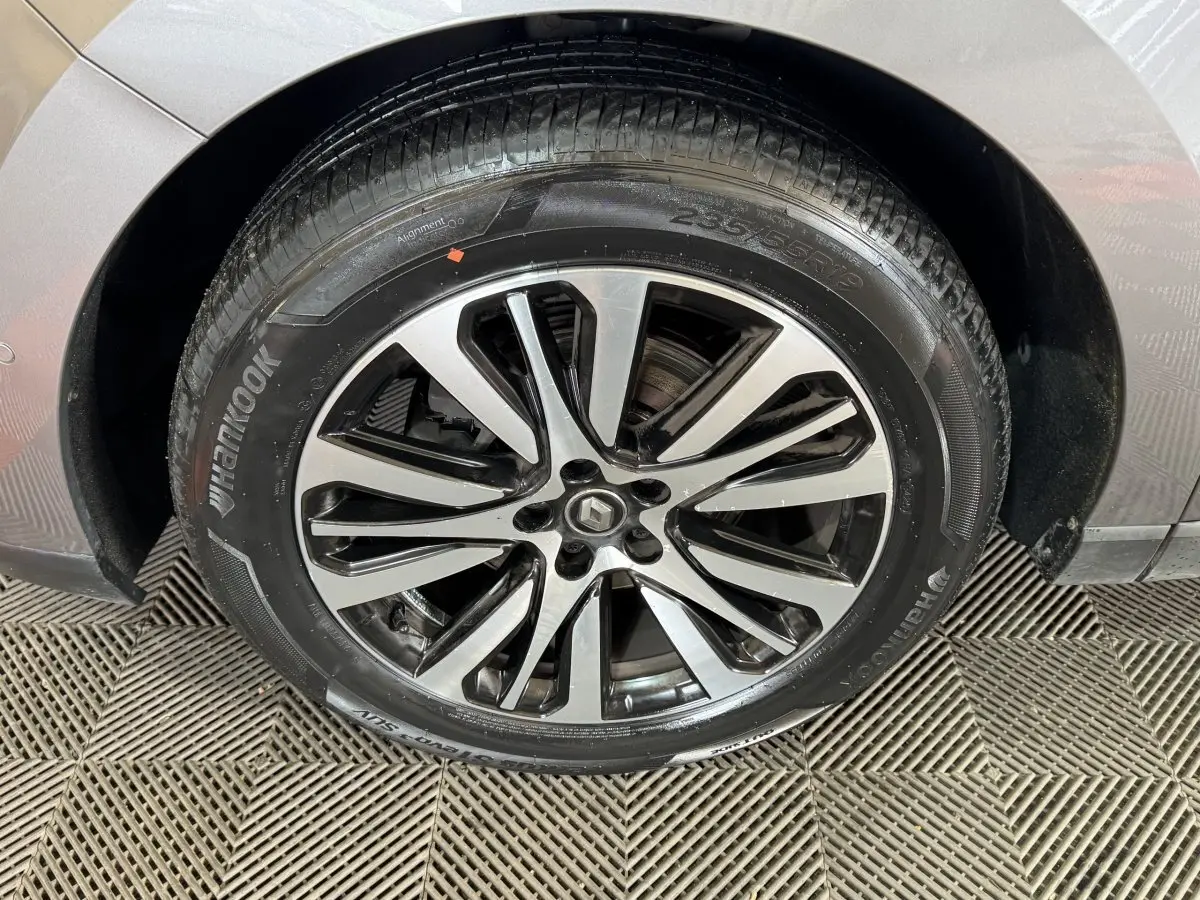 Gros plan sur la roue avant droite gris foncé de la Renault Espace Initiale Paris avec jante alliage bicolore et logo Renault central.