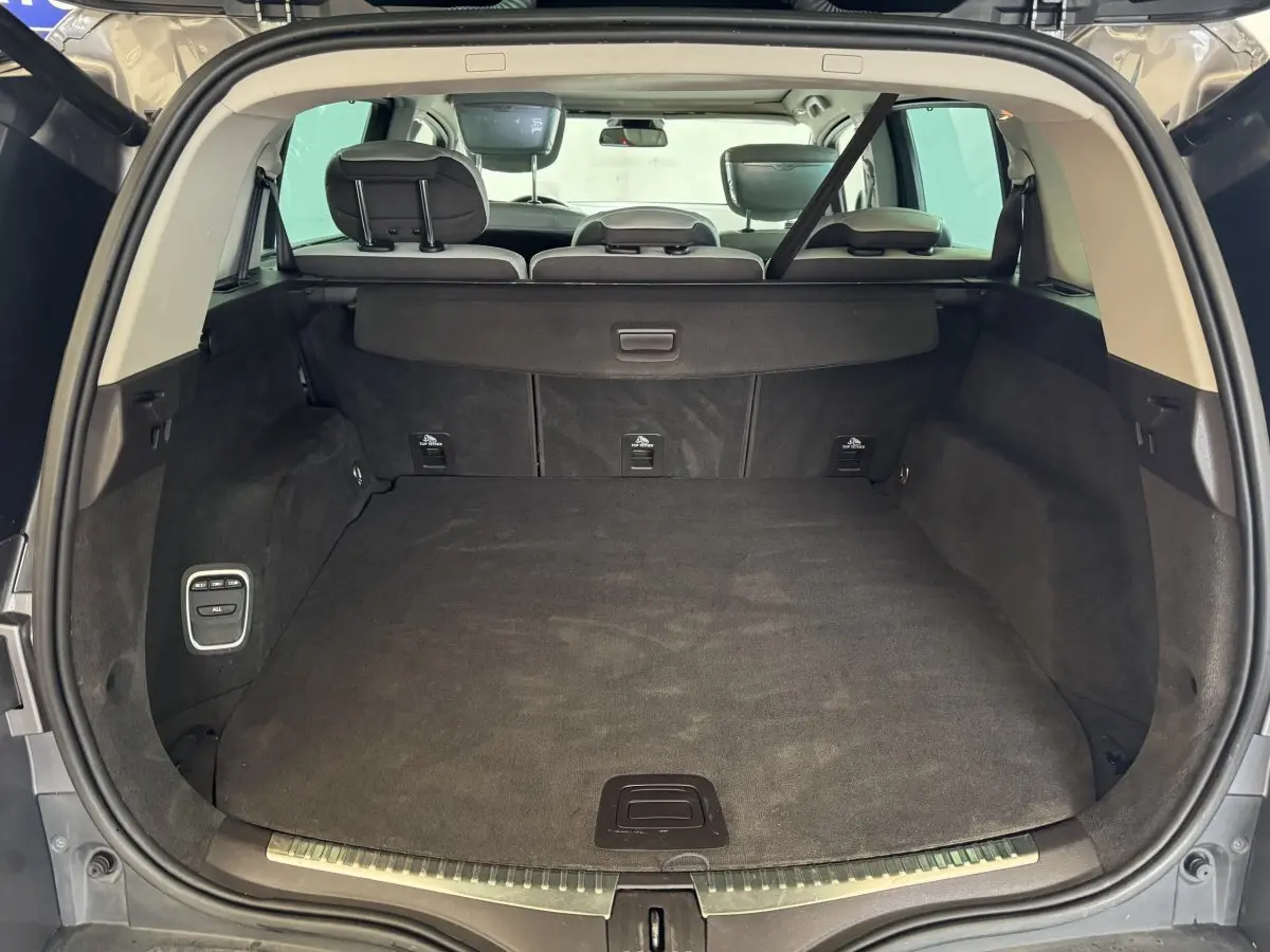 Vue arrière du coffre ouvert du Renault Espace gris foncé, montrant l'espace de chargement et les sièges arrière rabattables.