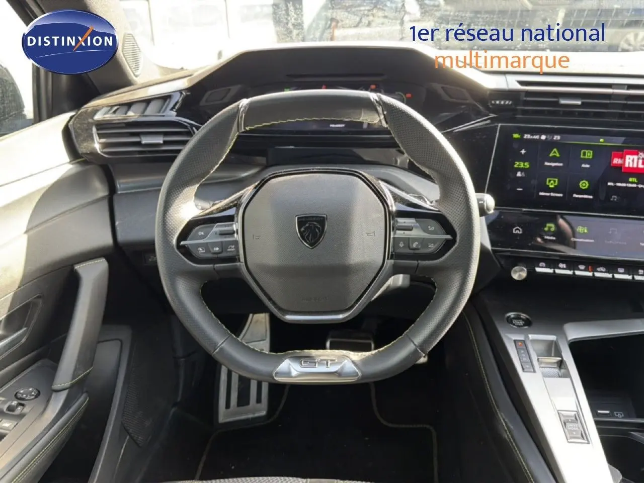 Vue intérieure centrée sur le volant cuir GT et le tableau de bord numérique de la Peugeot 408 gris selenium.