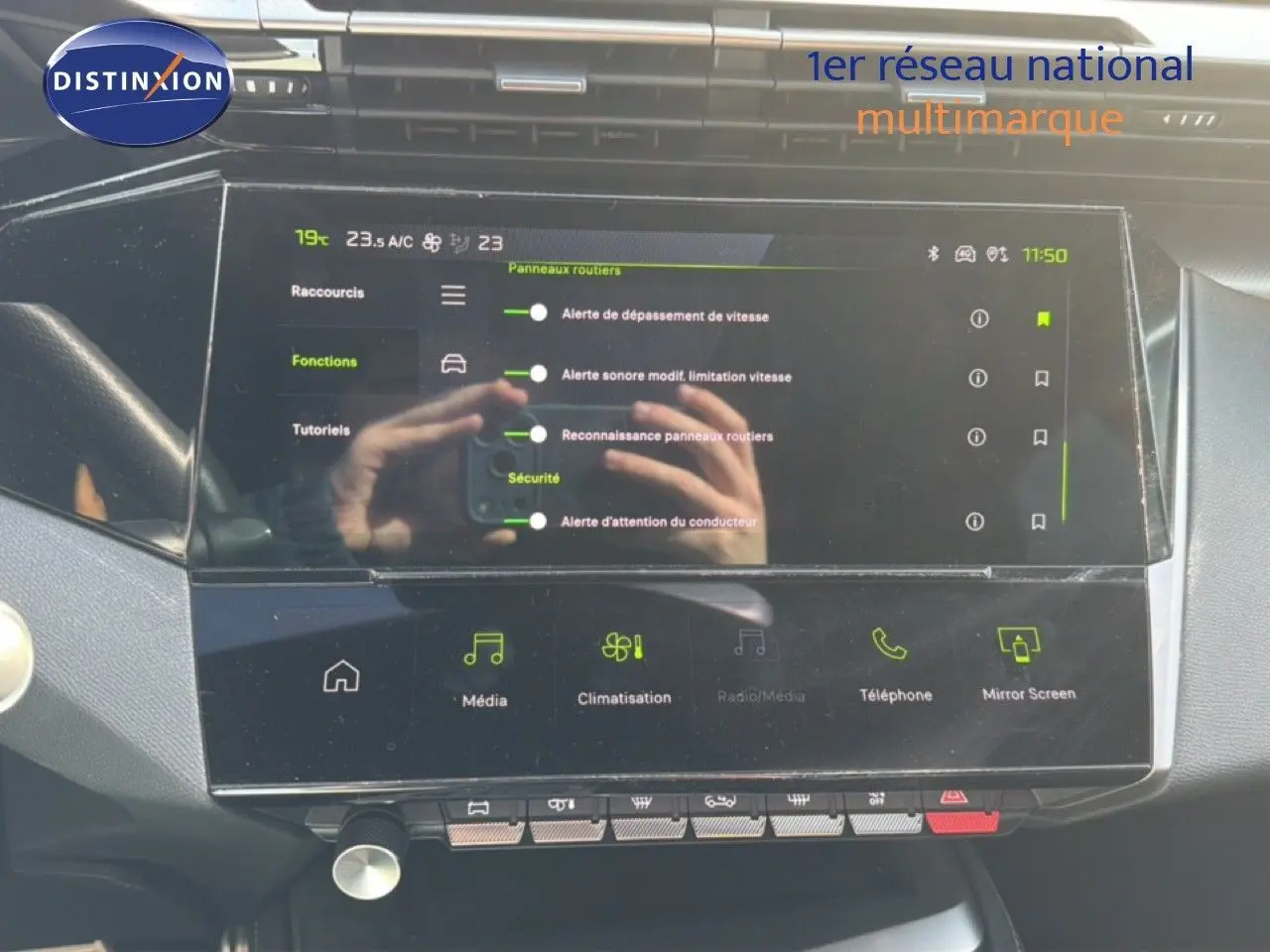 Écran tactile central du tableau de bord de la Peugeot 408 gris Selenium, affichant les réglages de sécurité et climatisation.