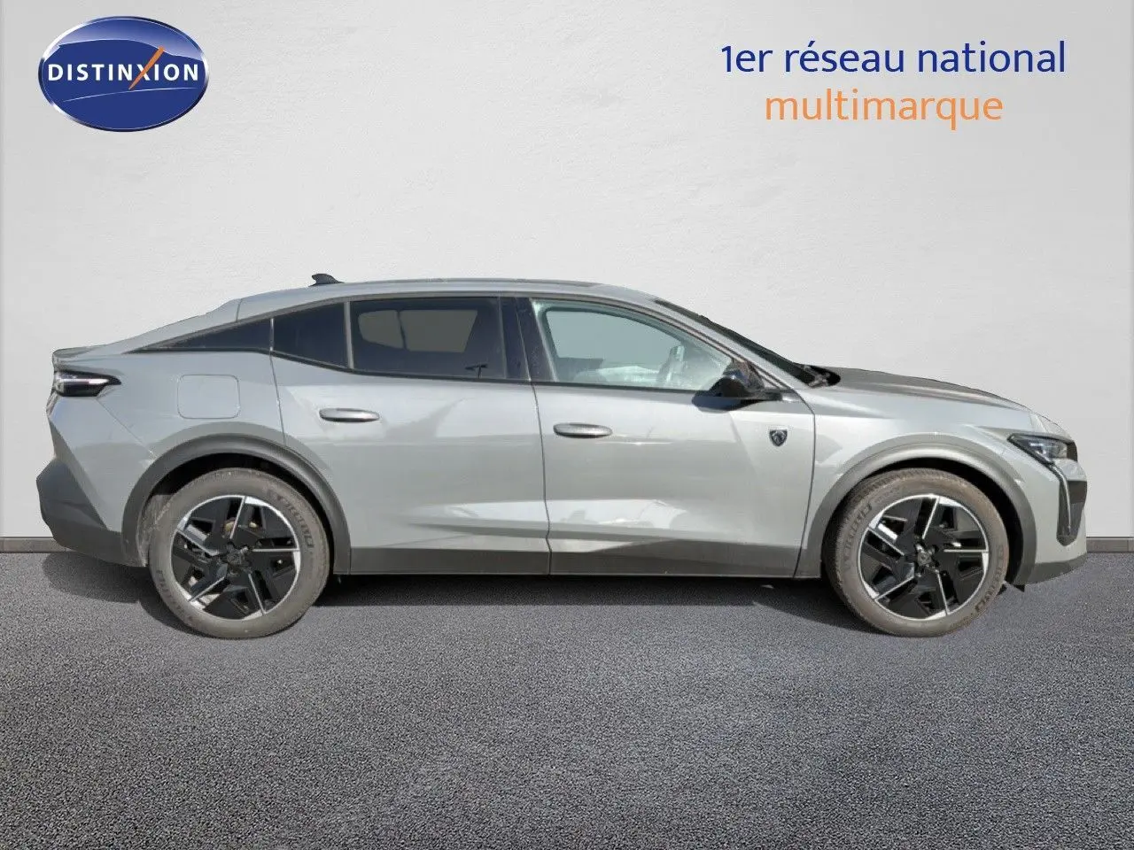 Profil côté droit d'une Peugeot 408 1.2 Hybrid 145ch GT gris selenium metal avec jantes noires et vitres teintées.