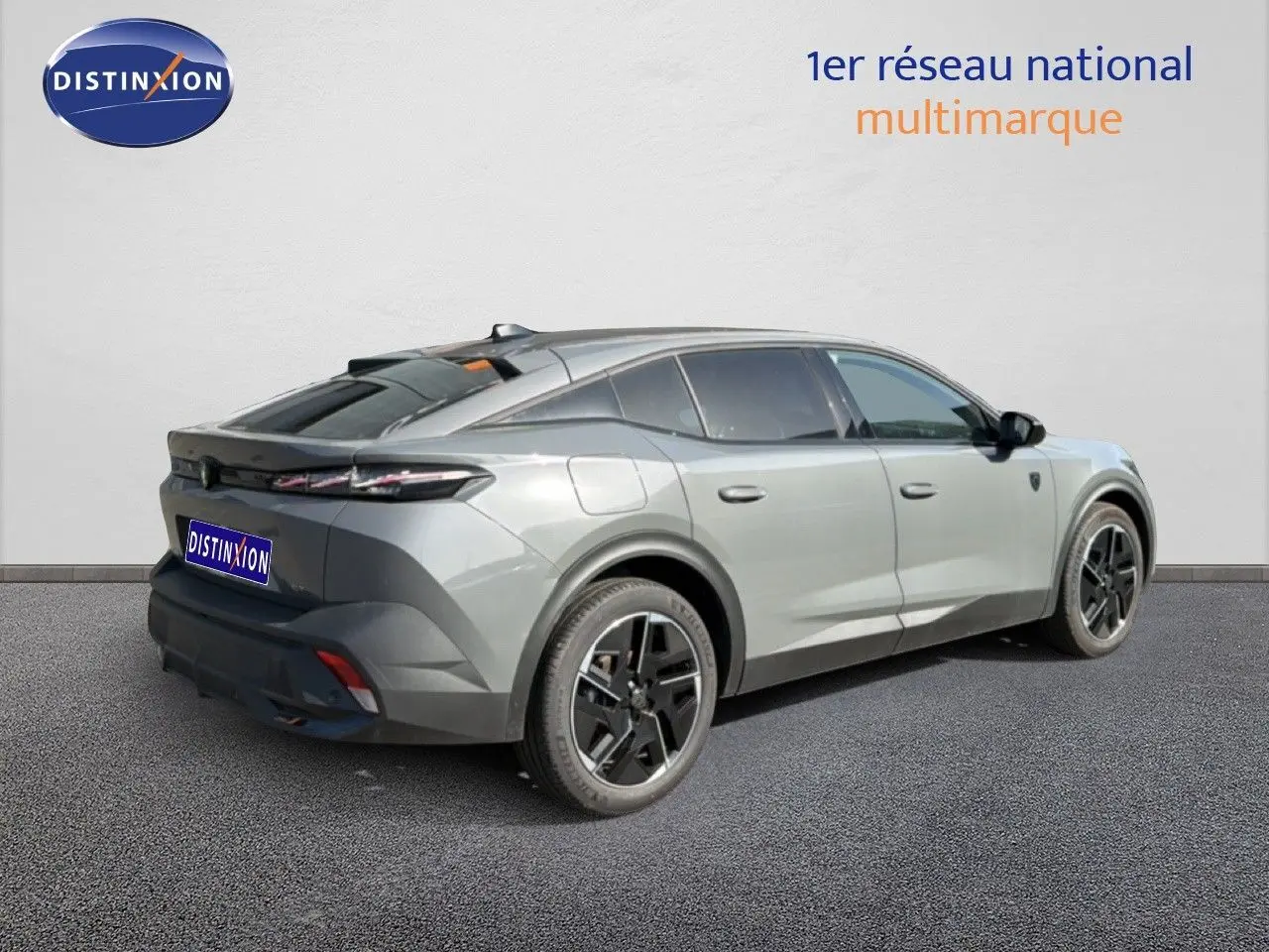 Vue 3/4 arrière droite de la Peugeot 408 gris selenium metal 2025 avec jantes noires et toit panoramique.